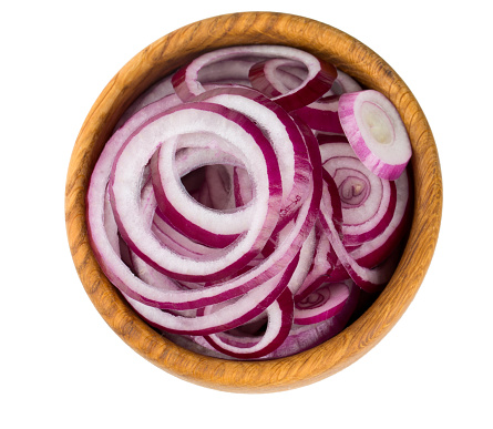 red onion slices in a wooden bowl isolated on white