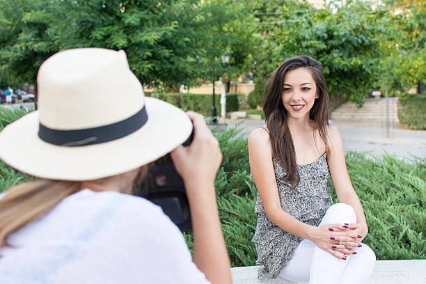 istock Two friends taking pictures in park 597211438