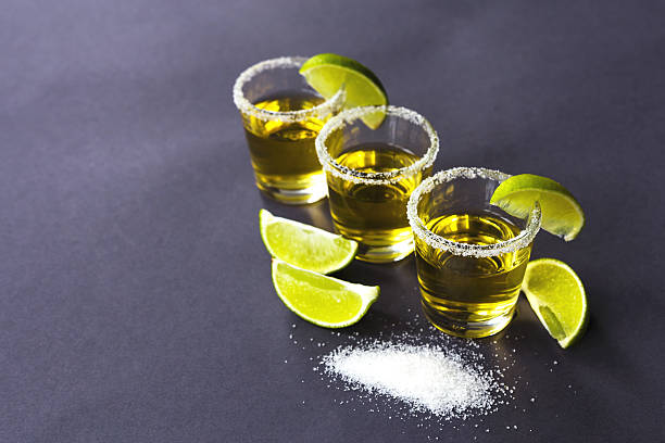 istock Gold tequila with lime and salt on dark table 597215226