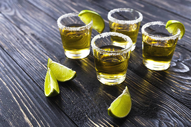 istock Gold tequila with lime and salt on dark table 597215426