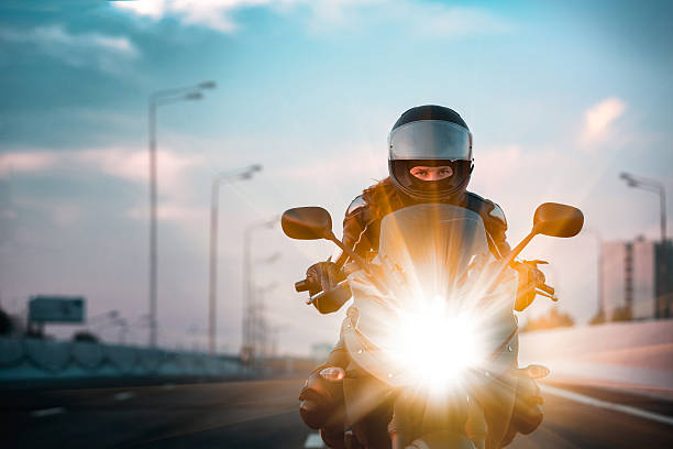 woman drives on a motorcycle on a morning highway - motocicleta imagens e fotografias de stock