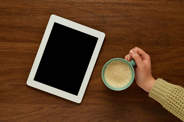 istock Top view of a tablet gadget on a wooden table 597218084