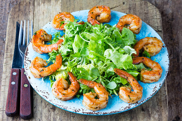 istock Seafood shrimp lettuce salad on blue plate 597219306