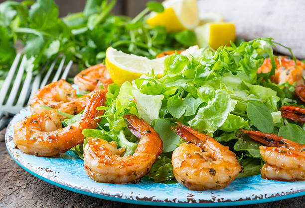 istock Seafood shrimp lettuce salad on blue plate 597219920
