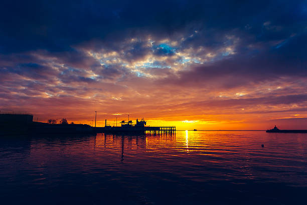 istock Harbor and boat under a colorful sunset. 597221192