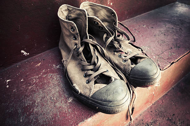 istock Pair of old sneakers on stairs. Retro stylized 597223268