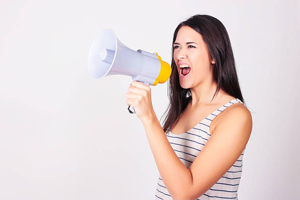 istock Young beautiful woman shouting through a megaphone 597223300