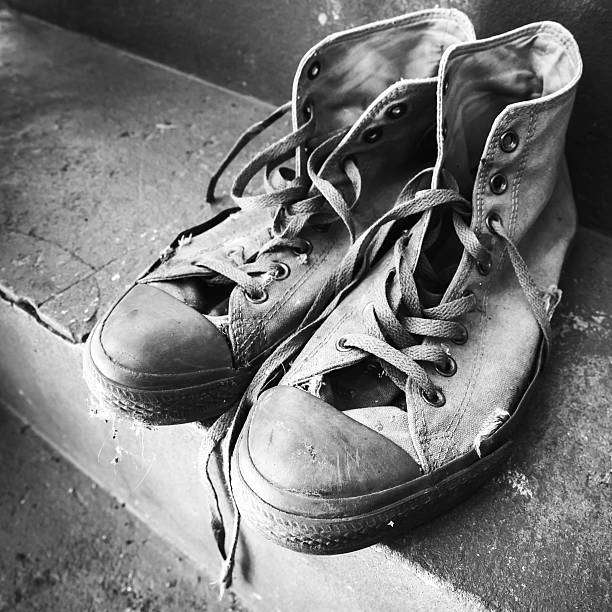 istock Old used sneakers standing on concrete 597223482