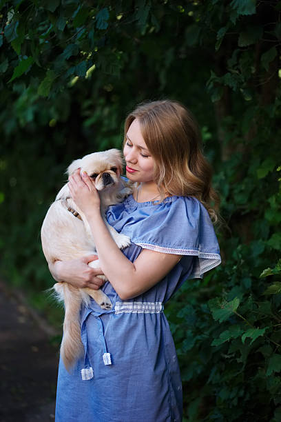 istock young beautiful girl with pekingese 597223942