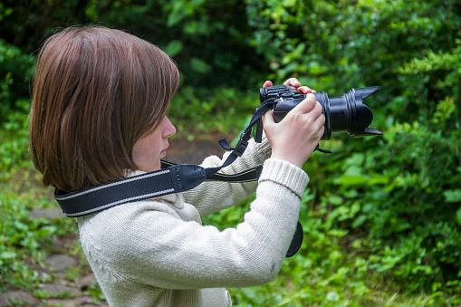 little girl shooting with big photo camera
