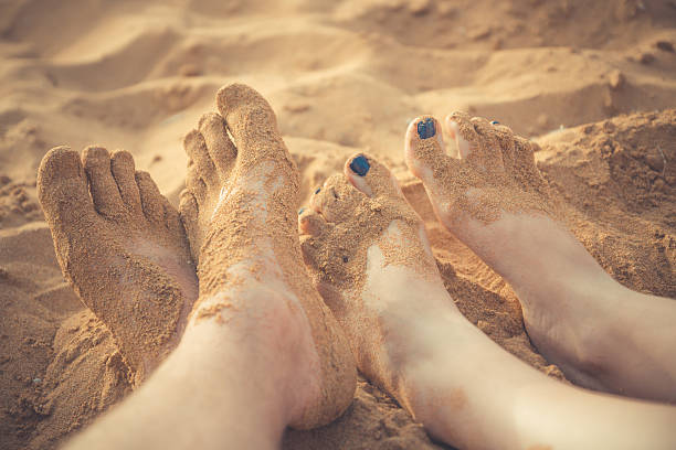 istock Legs on the beach next to the sea 597230064