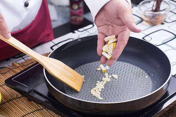 istock Chef putting slice of tofu to pan 597232778