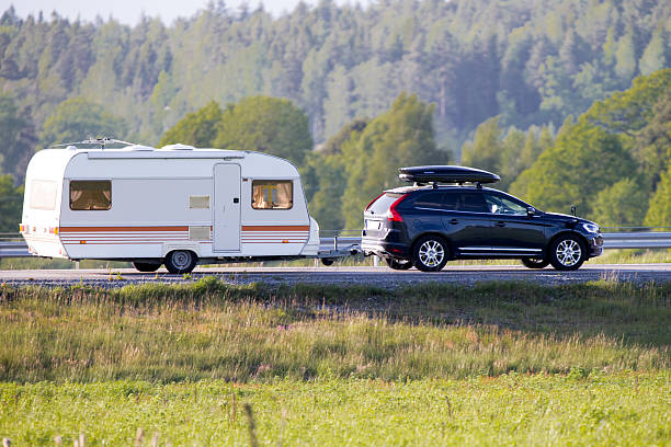 Travel trailer during summer Katrineholm, Sweden- June 7, 2015: Travel trailer pulled by a car that also has a ski box on the roof for extra space camper trailer photos stock pictures, royalty-free photos & images