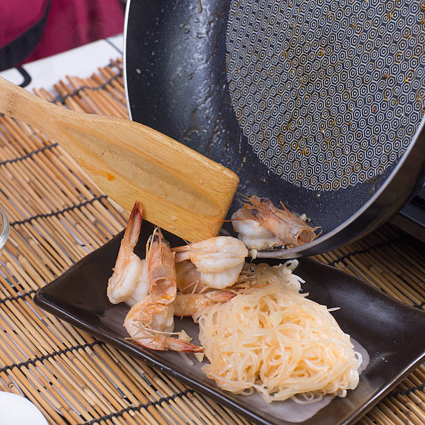 istock Chef putting stir fried shrimp to the plate 597233296