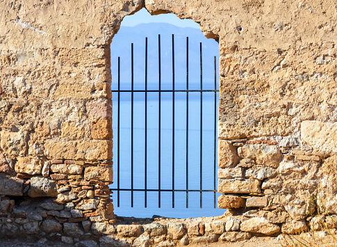 Window in old castle with view of the sea