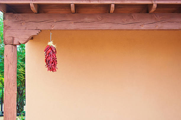 chili peppers ristras contra de santa fe estuco pared - ristra fotografías e imágenes de stock