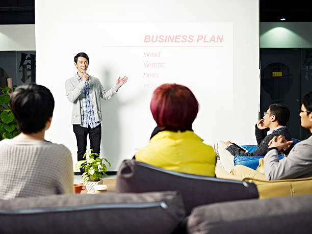 young asian man presenting business plan young asian entrepreneur presenting business plan for new project. founder photos stock pictures, royalty-free photos & images