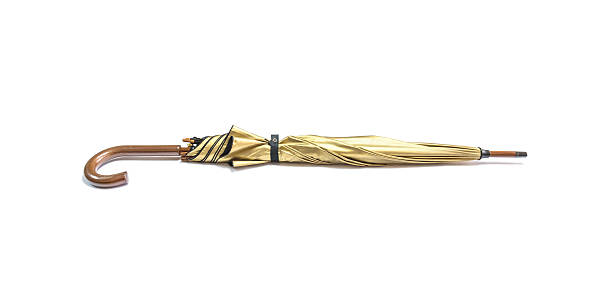 istock Closeup gold color umbrella isolated on white background 597245420