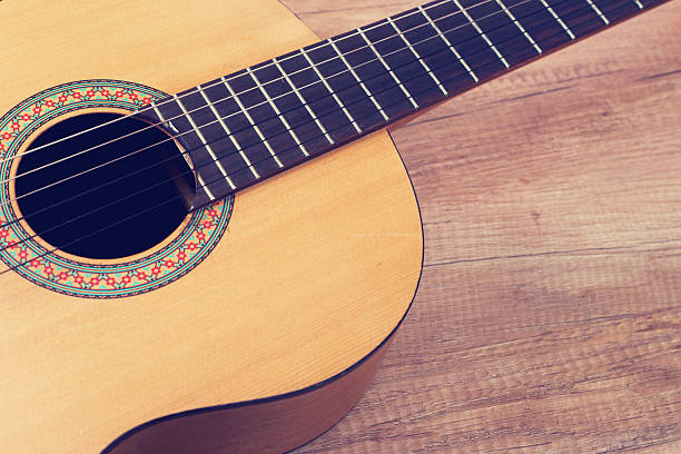 istock Acoustic guitar on wooden background 597248372