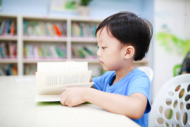 istock Cute asia children in the library 597254202