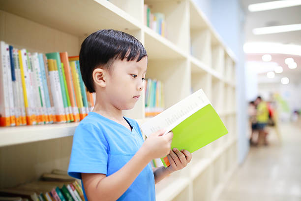 istock Cute asia children in the library 597254610