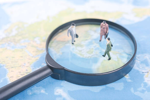 istock Miniature business people on magnifier and world map. 597256252