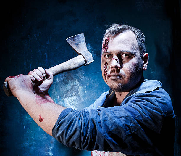 istock Bloody Halloween theme: crazy killer as butcher with an ax 597256282