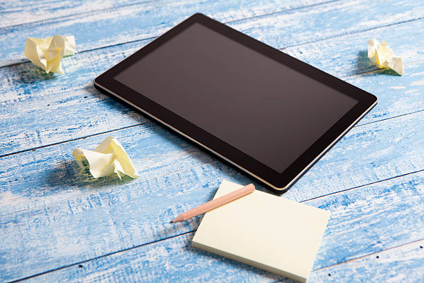 Digital tablet with sticky notes on old wood