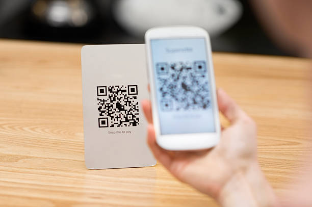 Scanning qr code Closeup of a hand holding phone and scanning qr code. Woman hand paying with qr code. Close up of customer hand making payment through smart phone and scan code. qr code photos stock pictures, royalty-free photos & images