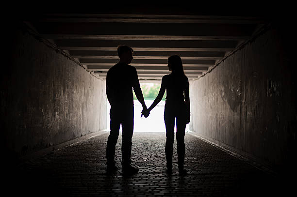 istock Silhouette of young couple holding hands 597261424