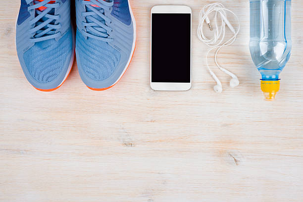 istock Sneakers, smartphone and water on wood with copyspace at bottom 597262268