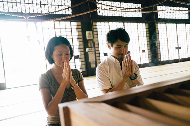 istock Japanese couple praying in a buddhist temple 597263902