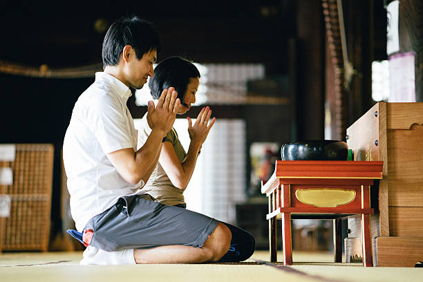 istock Japanese couple praying in a buddhist temple 597265034