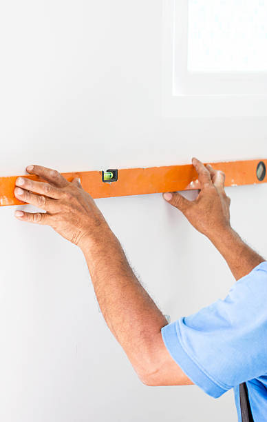 istock Asian Mans Hand Measuring A Wall With Spirit Level 597266086