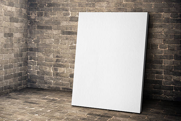 istock Blank white canvas frame leaning at grunge brick room 597266714