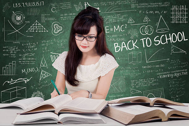 istock Girl writes on the book while reading 597267086