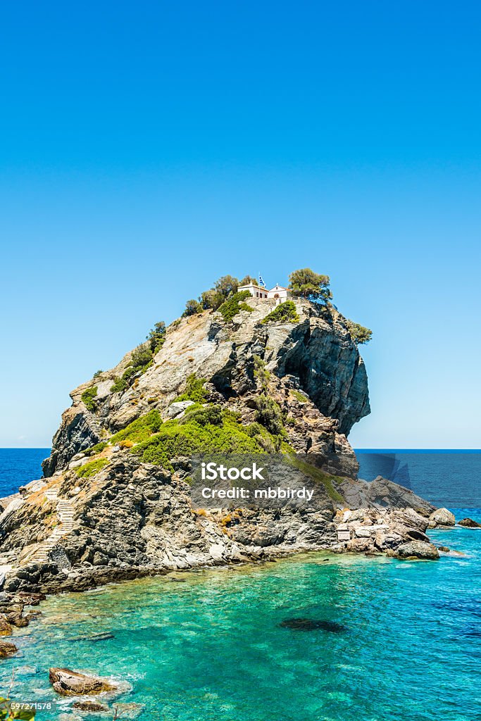 Rock with Agios Ioannis church on Skopelos island Rock with famous church Agios Ioannis Kastri on Skopelos island, Greece, where scenes of Mamma Mia! movie were filmed. Sun raises above Alonissos island. Skopelos Stock Photo