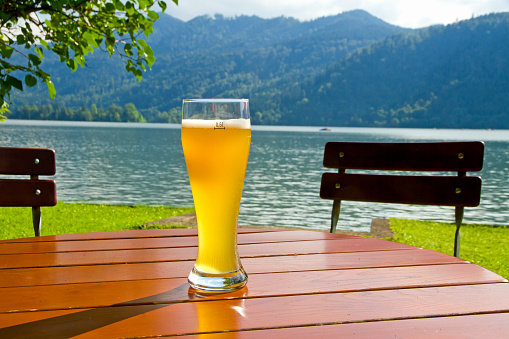Wheat beer standing on a wooden table on lake Schliersee - Bavaria, Germany