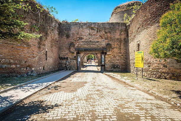 Iznik, Turkey - July 24, 2016: Turkish couple is passing through Istanbul gate of Nicea ancient city in Iznik, Turkey