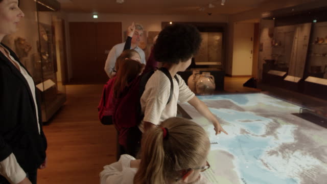 Pupils On School Trip To Museum Looking At Map Shot On R3D