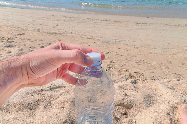 istock Watter bottle opening on hot summer day at the beach 597628738