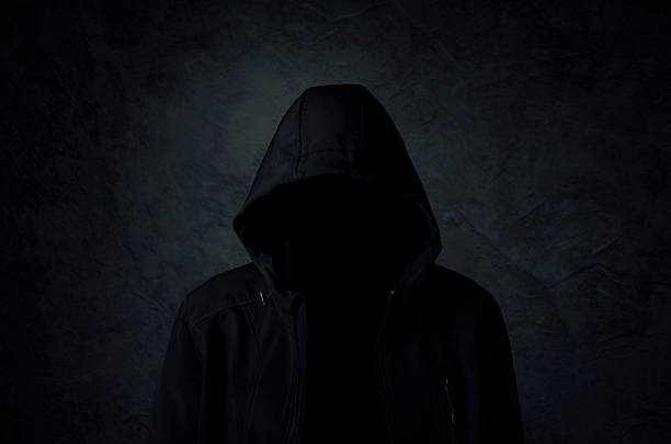 istock Hooded man over dark concrete background 597628884