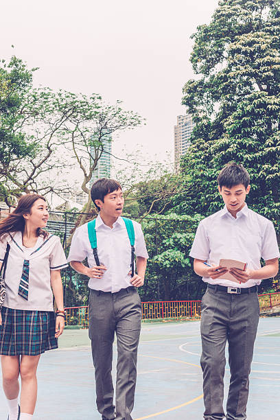 istock Three Chinese Students Walking on Basketball Ground, Hong Kong, China 597631244