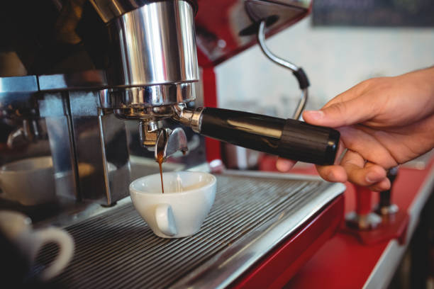 istock Close-up of waiter holding coffee maker handle at cafe 597631578