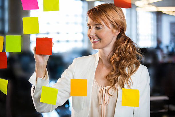 istock Businesswoman writing on adhesive notes 597631888