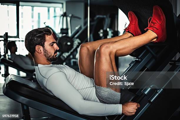 Man Focused On Training Legs On The Machine Stock Photo - Download Image Now - Leg Press, Men, Sports Training