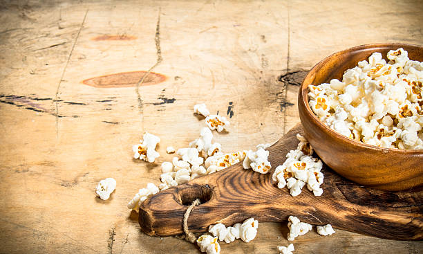 istock Popcorn in a wooden bowl on the Board. 597632766