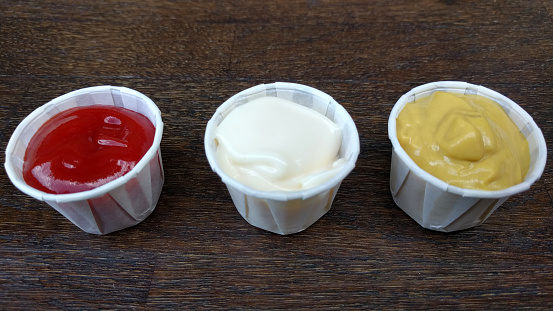 Ketchup, mayonnaise and mustard in disposable cups