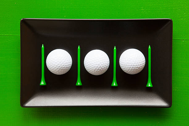 Black ceramic dishes with golf balls and wooden tees