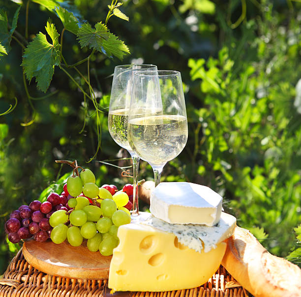 istock Various sorts of cheese and two white wine glasses 597638630